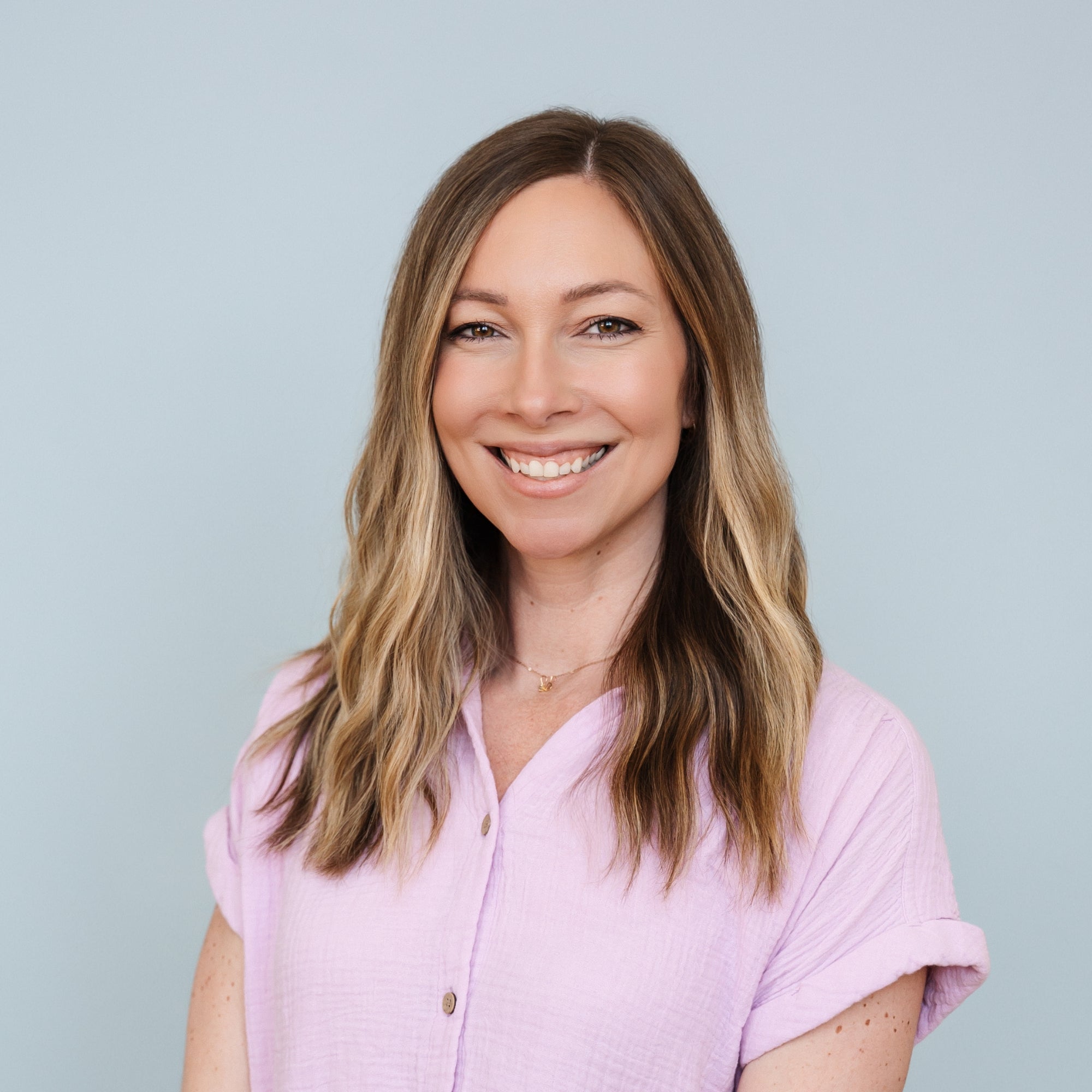 Woman that owns friday afternoons with long blonde hair wearing a light purple shirt against a light blue background