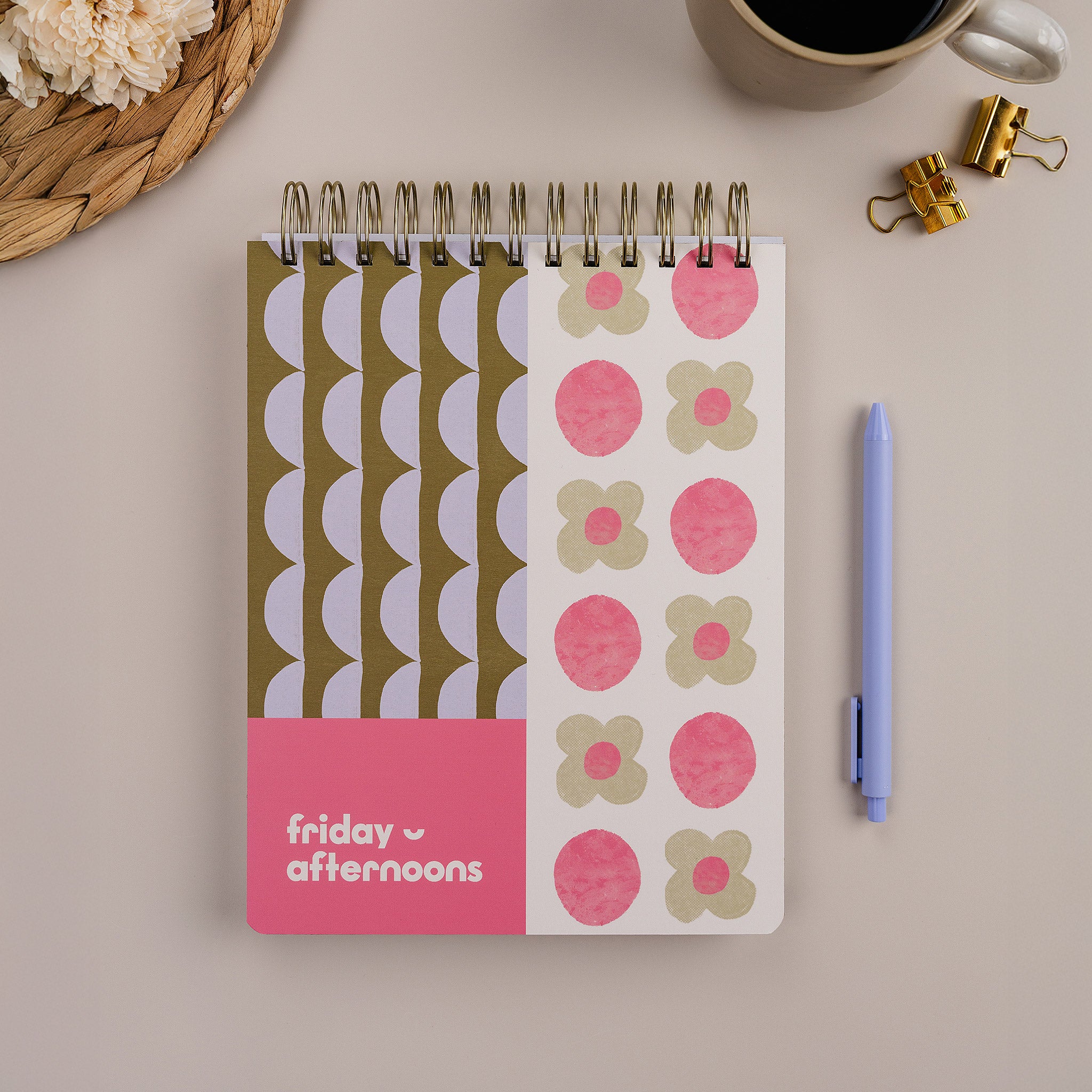 Lavender Scallop Workday Planner — top-spiral daily planner for work with pink and green patterned cover on desk.