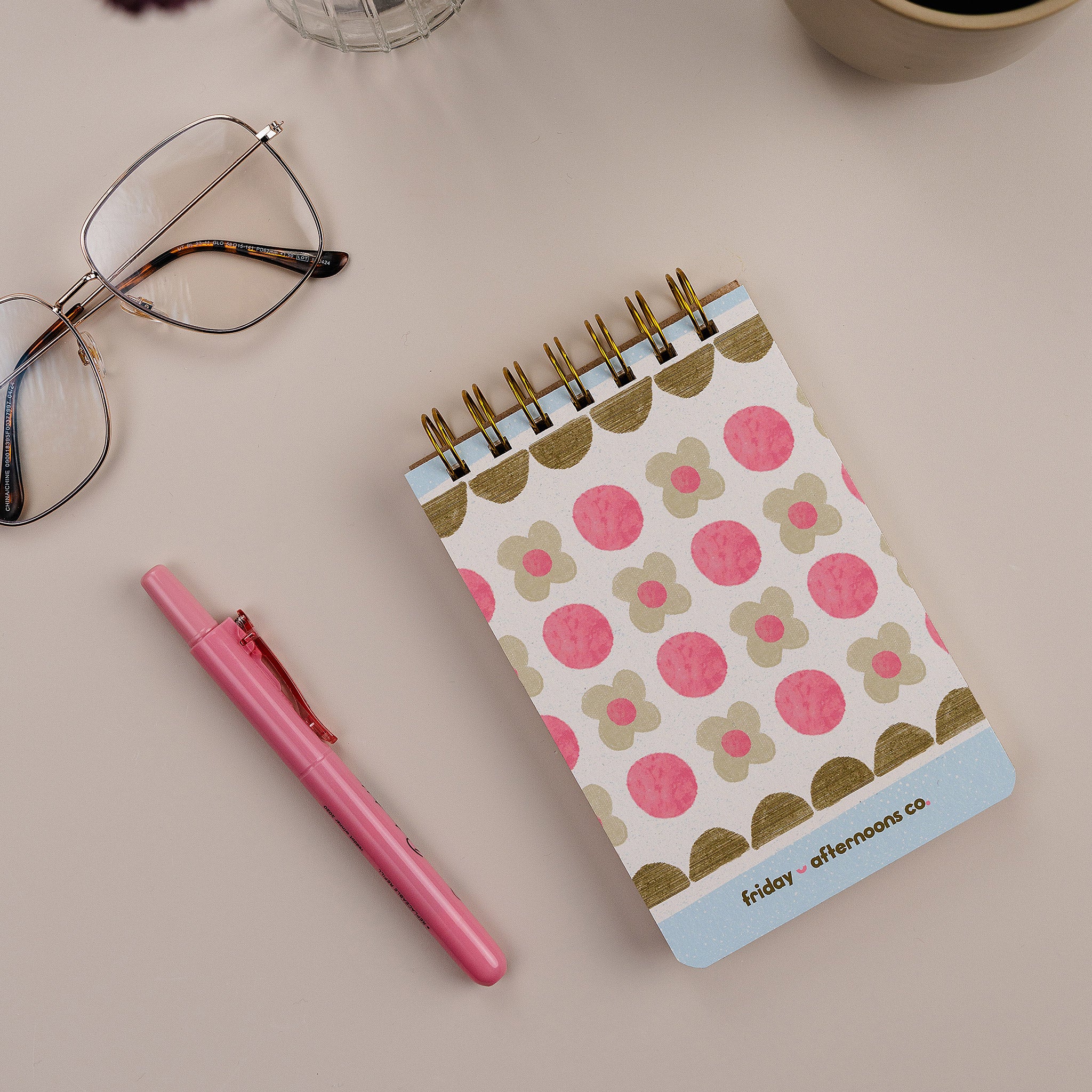 Mini Memo Notebook in Sage Blooms cover by Friday Afternoons Co., shown on a desk with pen and accessories.