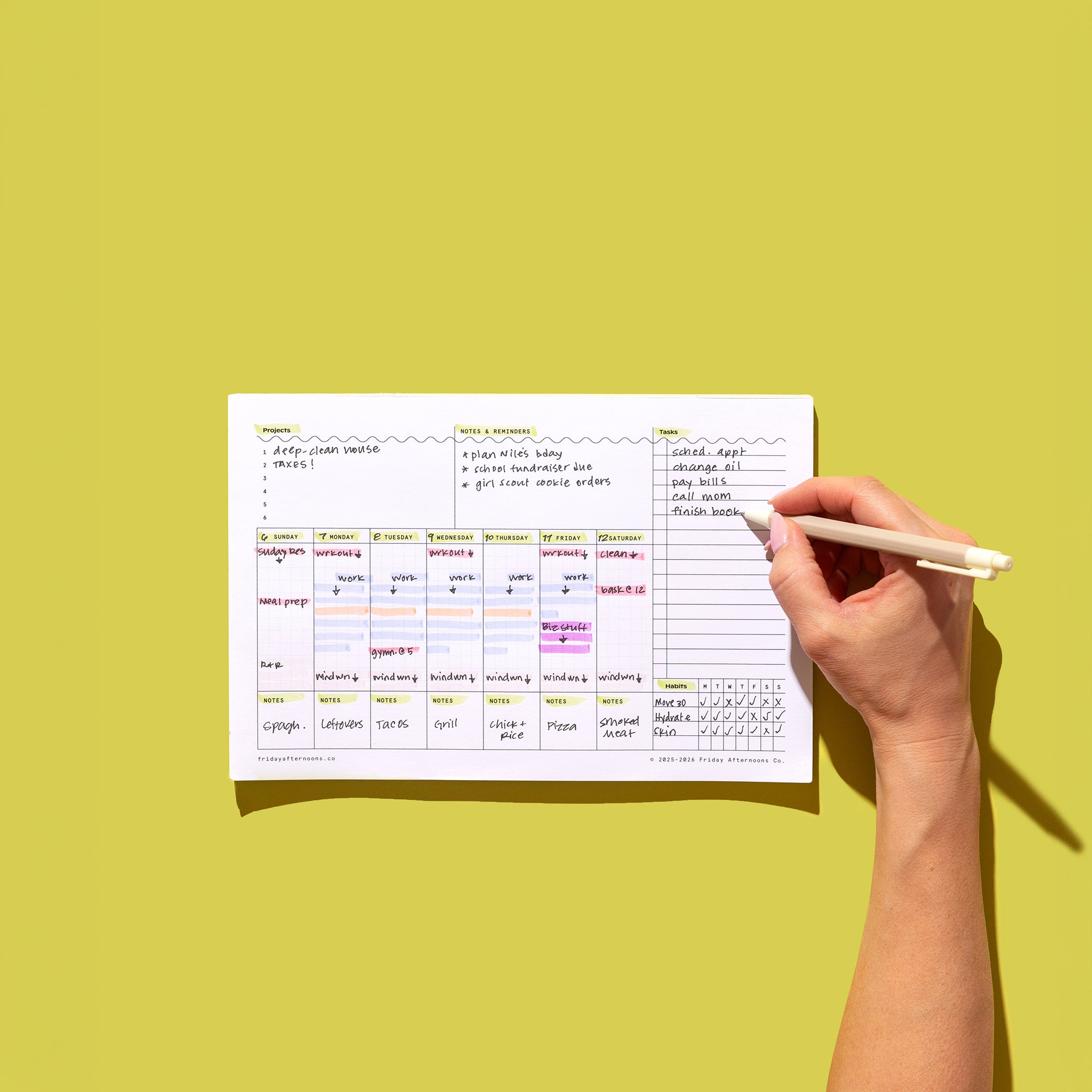 Weekly Task Tracker Notepad being filled in by hand with weekly tasks, habit tracker, project list, notes, and reminders on a green background.