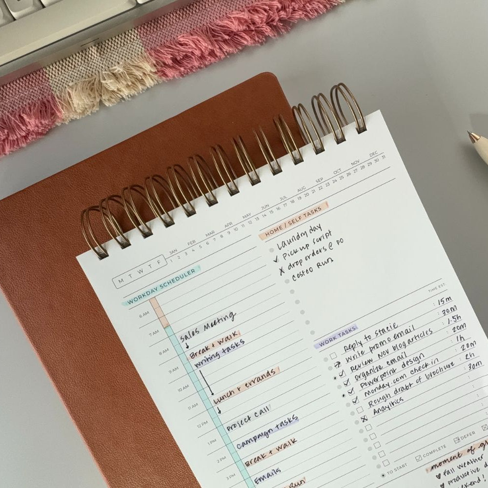 simple planner  on desk complete with time blocking examples intentional task management and prioritization with color coded highlights laid out on desk with accessories