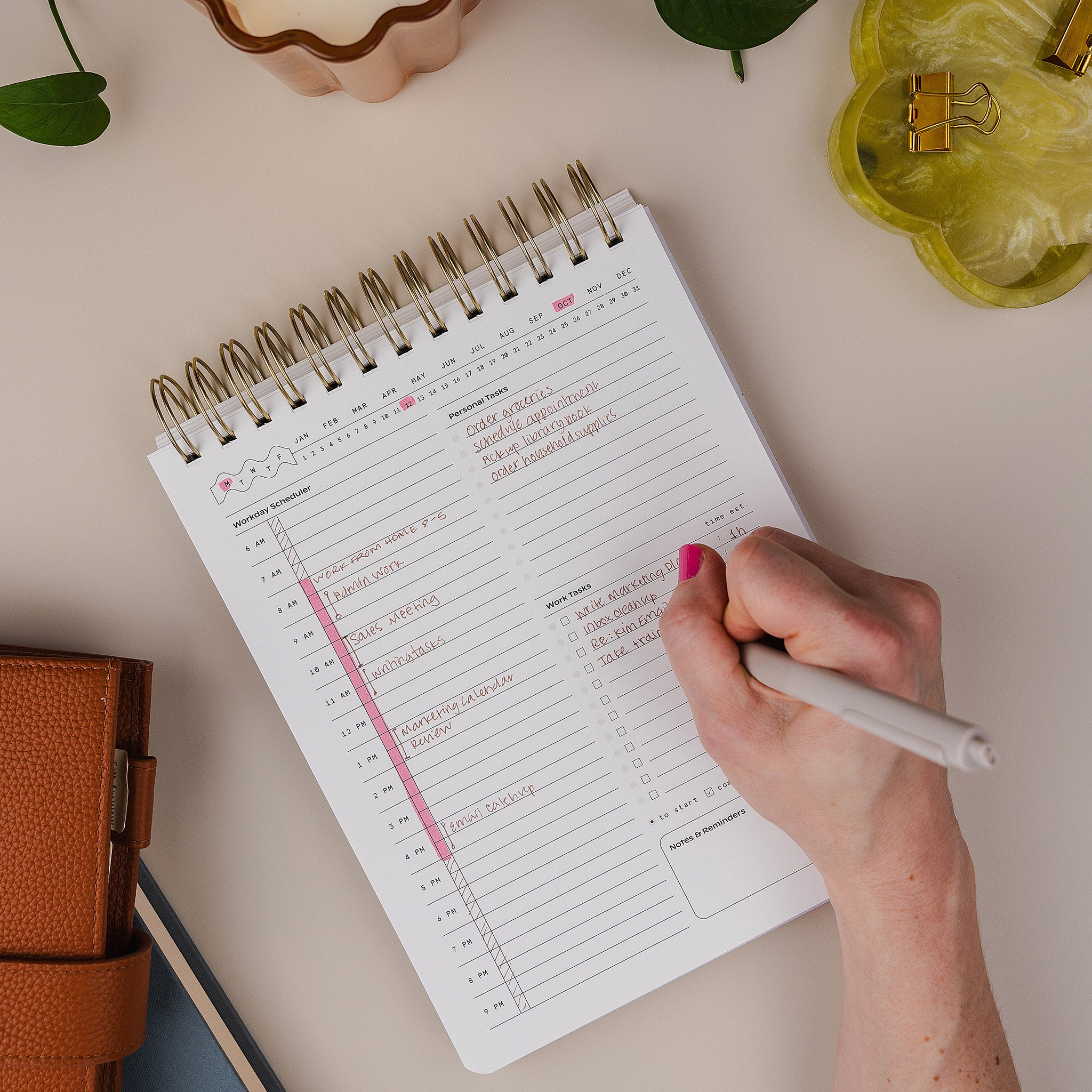 Hand writing in the Workday Planner daily page with time-blocking and task lists.