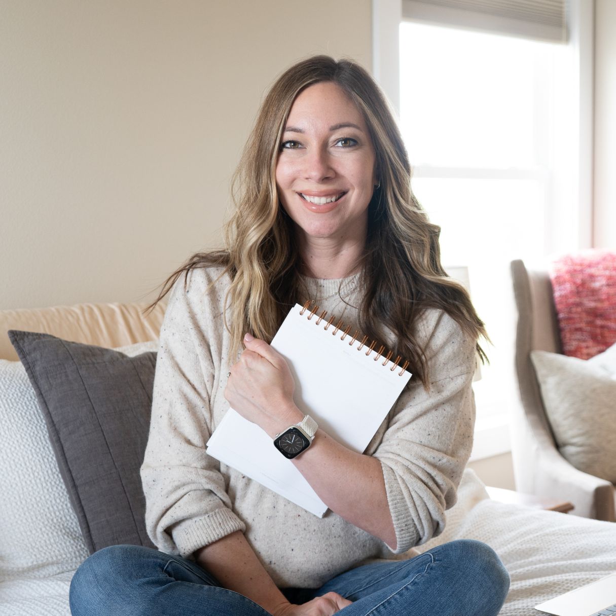 woman smiling at camera holding a daily planner