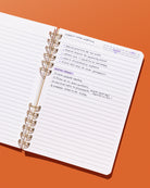 Daily Notes lined notebook filled with handwritten meeting notes, action items, and a marked date tracker.