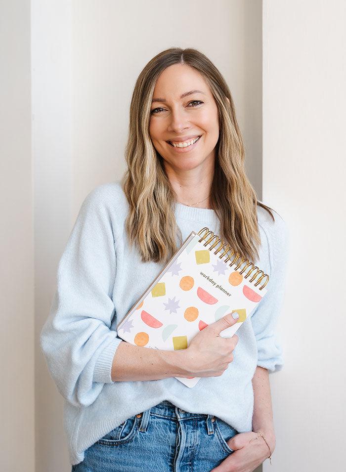 Danielle Dinville founder portrait holding daily planner — Friday Afternoons Co.