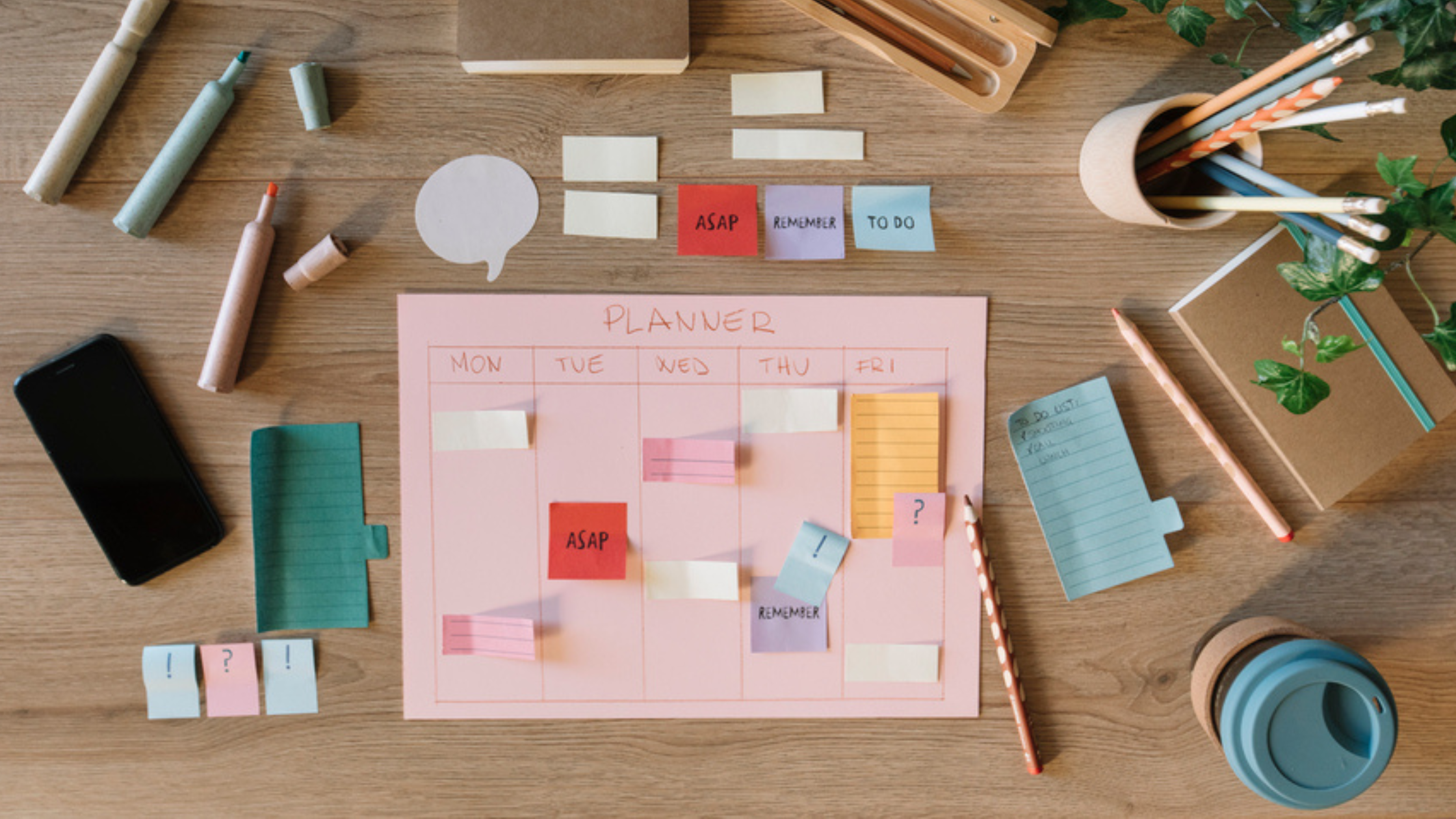 planning tools like post its pens pencils highlighters scattered on a desk