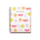 Bright Shapes Quarterly Plans 90-Day Planner front cover with gold spiral binding, geometric pattern, pink shapes, and white background