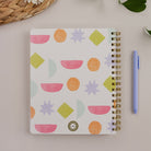 Bright Shapes Quarterly Planner styled with pen and office accessories on neutral desk surface.