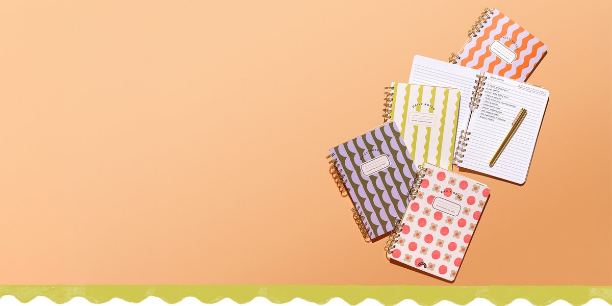 Four colorful Daily Notes spiral-bound notebooks by Friday Afternoons Co., including an open notebook with lined pages and handwritten notes, arranged on a peach background.