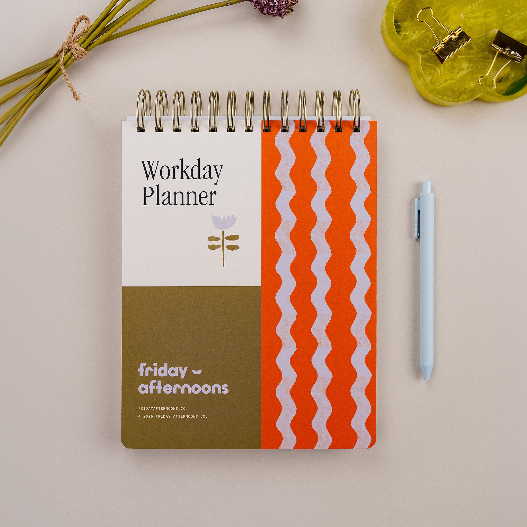 Tulip Wave Workday Planner — top-spiral daily planner for work with pink and green patterned cover on desk.