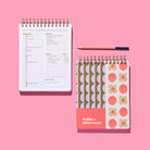 Lavender Scallop Workday Planner with an open daily planning page, patterned cover, and pink-and-blue pencil on a pink background.